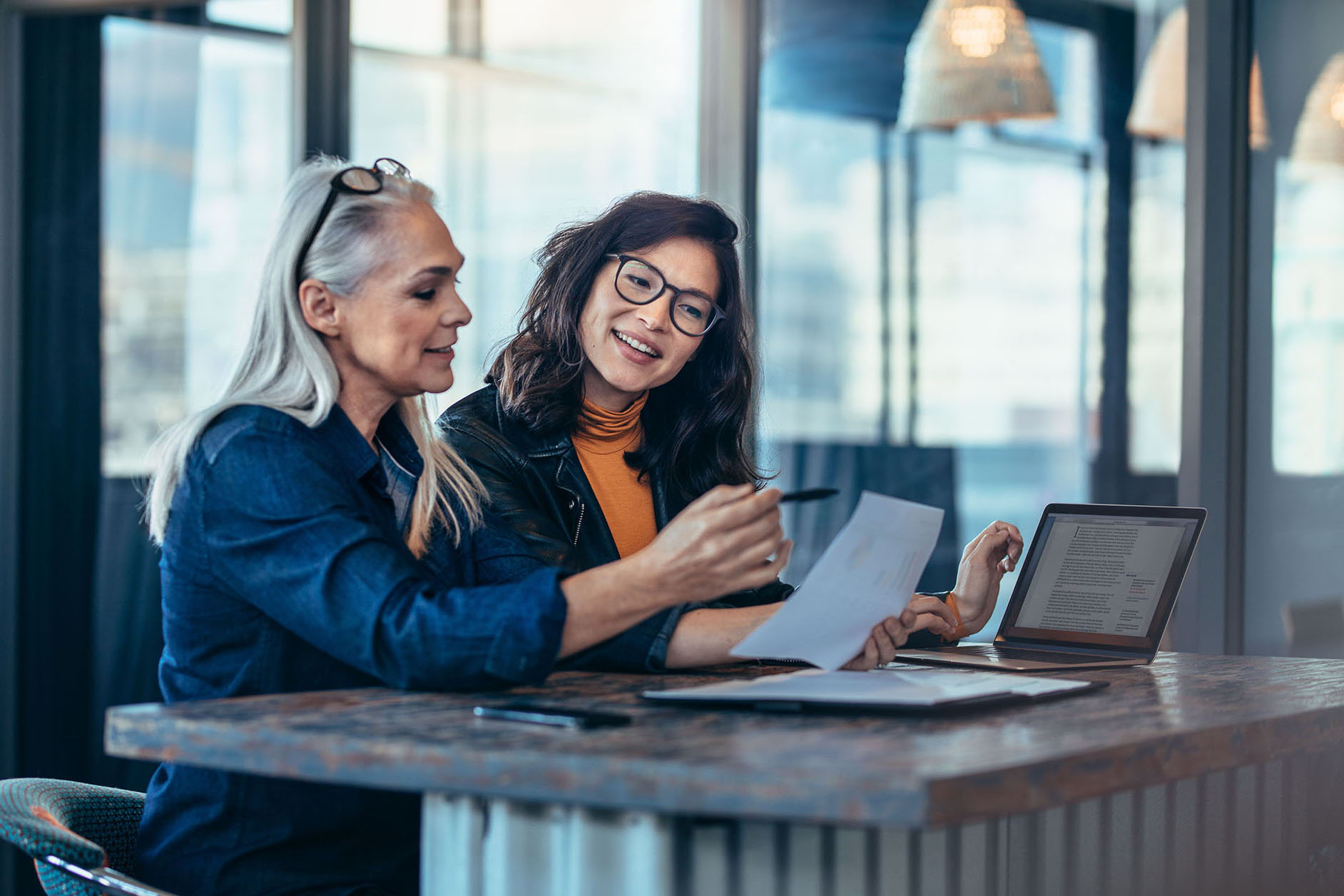 Two women analyzing reports at office